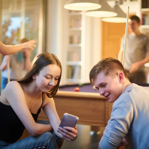 A young man and a young women looking at a mobile phone