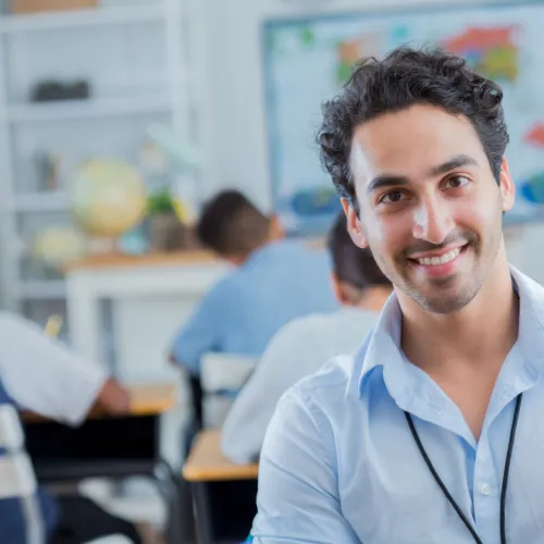 Man smiling at camera in classroom setting